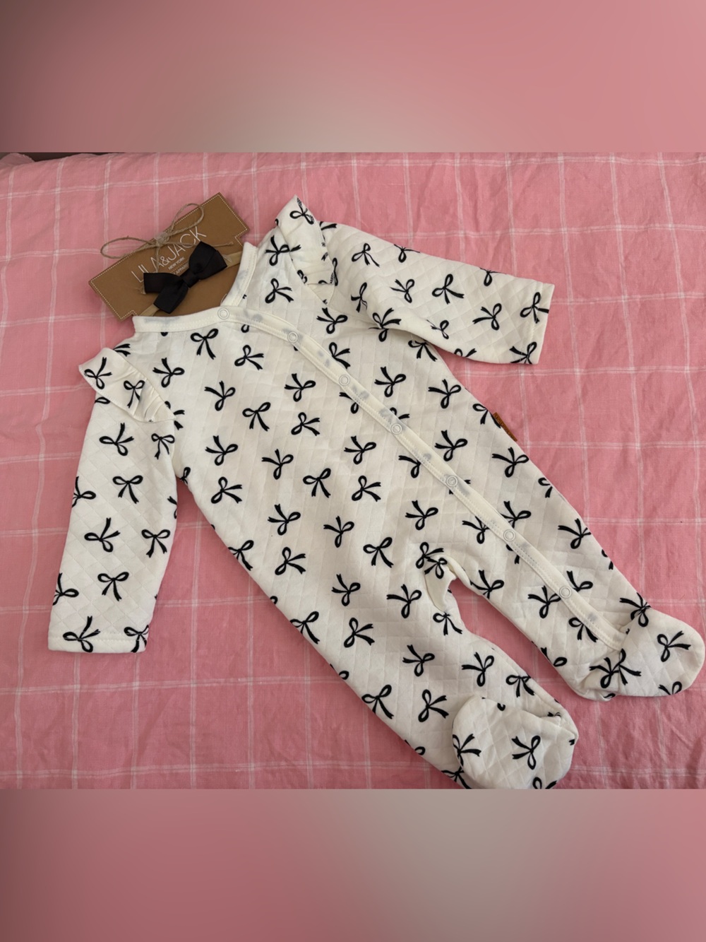Adorable cream and black bow print baby footie onesie with matching bow headband